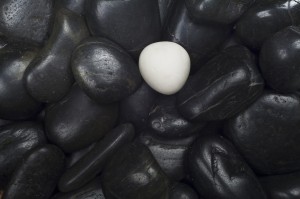 black pebbles, one white stone