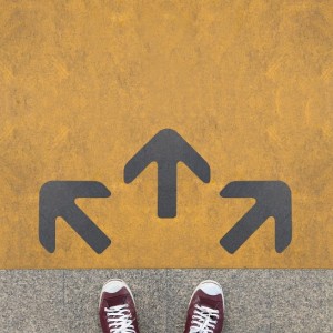 Pair of shoes standing on a road with three grey arrow on the yellow background